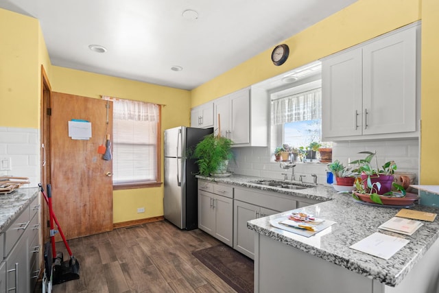 8014 W Summerdale Ave, Chicago, IL 60656 - kitchen with a sink, freestanding refrigerator, dark wood-style floors, decorative backsplash, and light stone counters