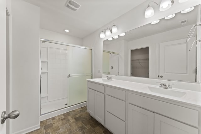 6712 Eich Dr, Joliet, IL 60431 - full bathroom featuring a stall shower, double vanity, stone finish flooring, and a walk in closet