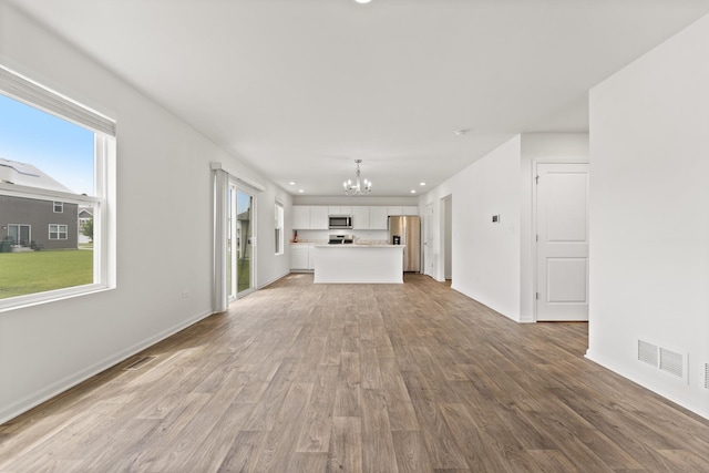 6712 Eich Dr, Joliet, IL 60431 - unfurnished living room with a chandelier, light wood-style flooring, baseboards, and recessed lighting