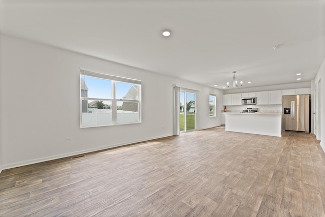 6712 Eich Dr, Joliet, IL 60431 - unfurnished living room featuring a chandelier, recessed lighting, light wood-type flooring, and baseboards