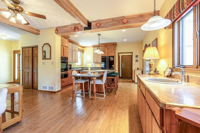 3206 Turnberry Dr, Mchenry, IL 60050 - kitchen featuring black appliances, a sink, beam ceiling, light wood-style flooring, and a kitchen bar