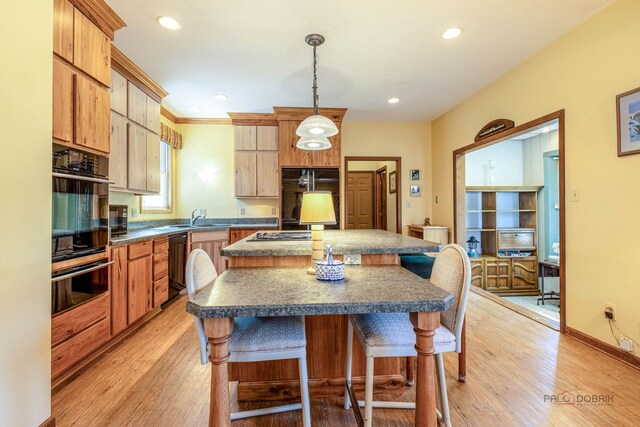3206 Turnberry Dr, Mchenry, IL 60050 - kitchen with black appliances, a sink, dark countertops, a breakfast bar, and a kitchen island