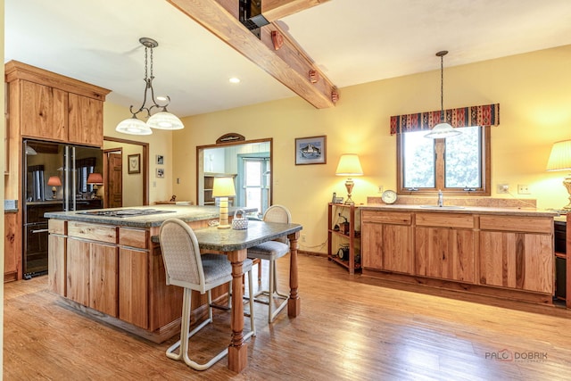3206 Turnberry Dr, Mchenry, IL 60050 - kitchen featuring black refrigerator, a sink, light wood finished floors, a kitchen island, and beamed ceiling