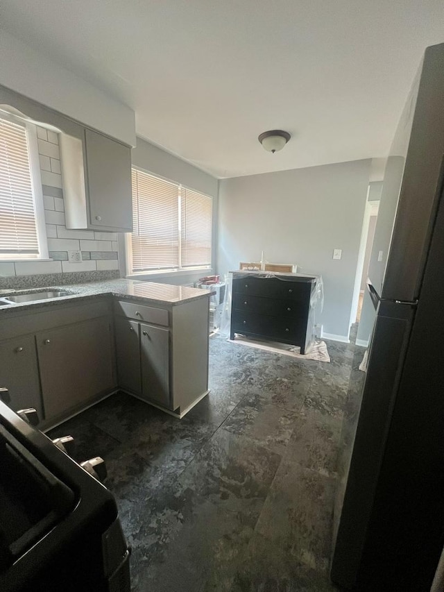 1100 Hannah Ave Unit 104, Forest Park, IL 60130 - kitchen featuring gray cabinetry, a peninsula, freestanding refrigerator, and a sink