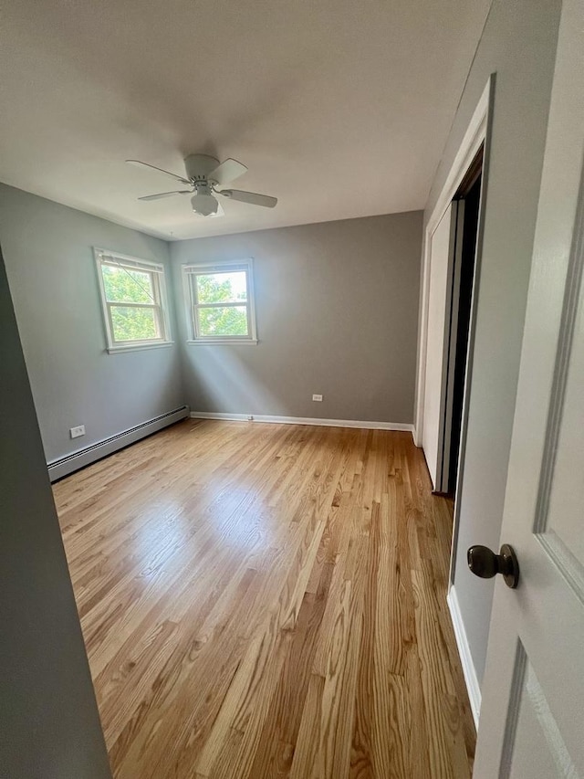 1100 Hannah Ave Unit 104, Forest Park, IL 60130 - unfurnished bedroom with a baseboard heating unit, light wood-style flooring, baseboards, a closet, and a ceiling fan