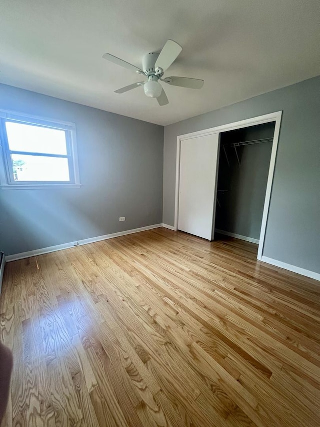 1100 Hannah Ave Unit 104, Forest Park, IL 60130 - unfurnished bedroom with light wood-style flooring, baseboards, a ceiling fan, and a closet
