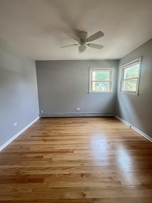 1100 Hannah Ave Unit 104, Forest Park, IL 60130 - spare room with a ceiling fan, light wood-type flooring, baseboards, and a baseboard heating unit