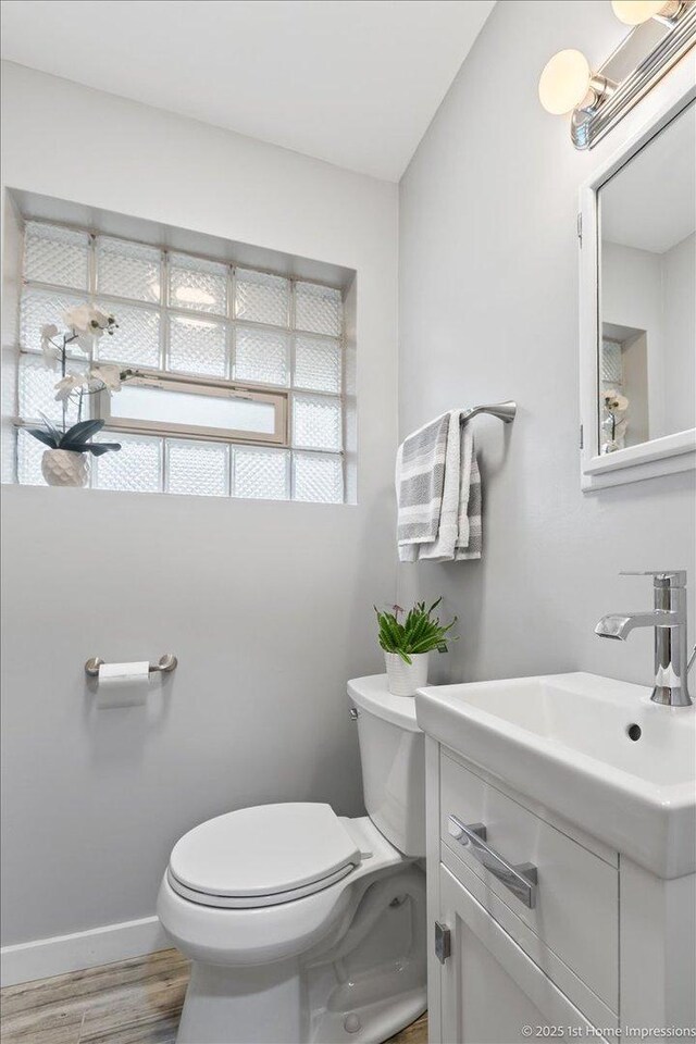 9544 S Avers Ave, Evergreen Park, IL 60805 - bathroom featuring toilet, vanity, wood finished floors, and baseboards