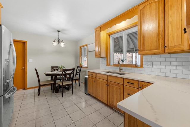 5111 S Luna Ave, Chicago, IL 60638 - kitchen with stainless steel fridge with ice dispenser, a sink, backsplash, a chandelier, and light countertops