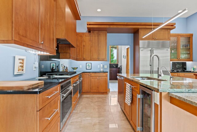 515 Stone Ridge Ln, Cherry Valley, IL 61016 - kitchen featuring beverage cooler, stainless steel appliances, light stone counters, brown cabinets, and glass insert cabinets
