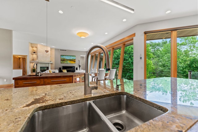 515 Stone Ridge Ln, Cherry Valley, IL 61016 - kitchen with a fireplace, brown cabinetry, recessed lighting, light stone countertops, and open floor plan