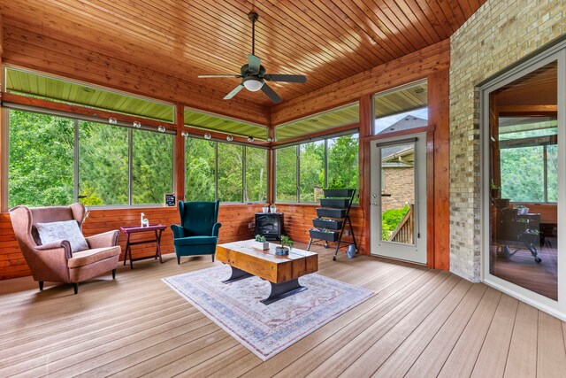 515 Stone Ridge Ln, Cherry Valley, IL 61016 - sunroom / solarium with a wood stove, a ceiling fan, a deck, hardwood / wood-style floors, and wood ceiling