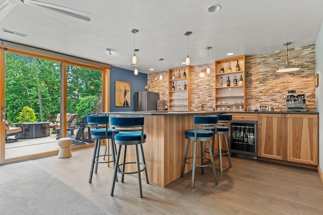 515 Stone Ridge Ln, Cherry Valley, IL 61016 - indoor wet bar with beverage cooler, light wood-style flooring, freestanding refrigerator, pendant lighting, and recessed lighting