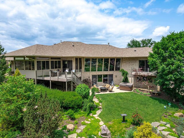 515 Stone Ridge Ln, Cherry Valley, IL 61016 - rear view of property with a patio area, a sunroom, a deck, a hot tub, and a yard
