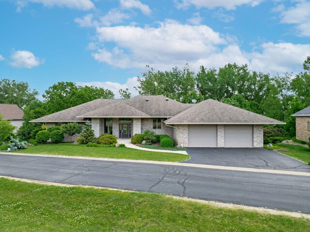 515 Stone Ridge Ln, Cherry Valley, IL 61016 - ranch-style home featuring a garage, asphalt driveway, a front lawn, roof with shingles, and brick siding
