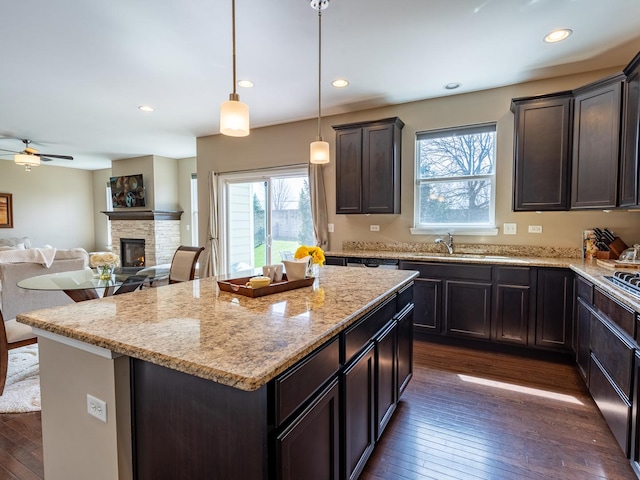 3740 Ryder Ct, Naperville, IL 60564 - kitchen featuring dark wood-type flooring, a sink, a kitchen island, a fireplace, and dark brown cabinetry