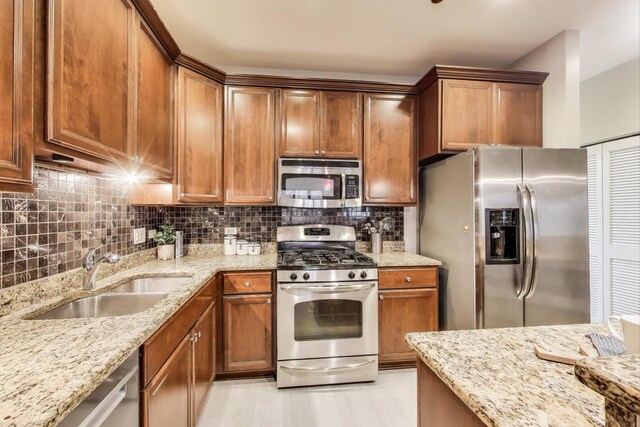 4950 N Western Ave Unit 101, Chicago, IL 60625 - kitchen with stainless steel appliances, a sink, tasteful backsplash, light stone countertops, and brown cabinets