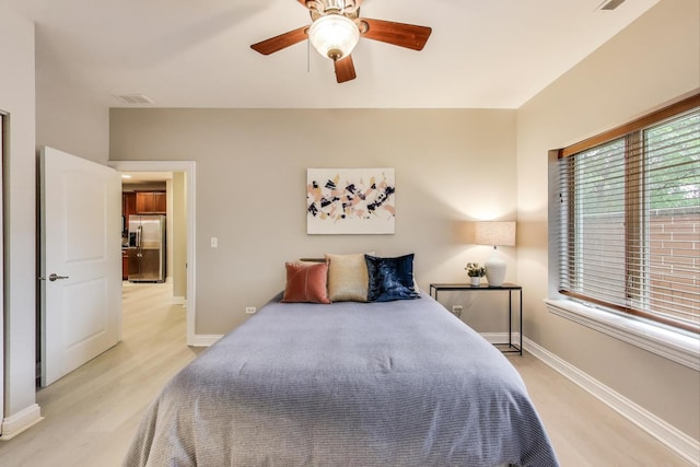 4950 N Western Ave Unit 101, Chicago, IL 60625 - bedroom with stainless steel fridge, light wood-style flooring, a ceiling fan, and baseboards