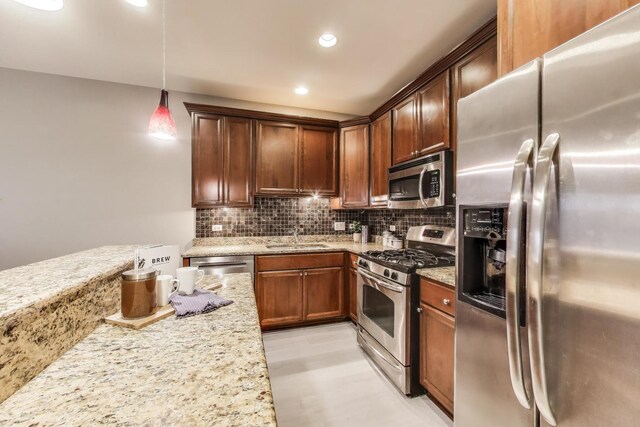 4950 N Western Ave Unit 101, Chicago, IL 60625 - kitchen featuring stainless steel appliances, light stone countertops, backsplash, hanging light fixtures, and a sink