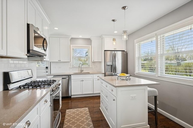 907 N Wilshire Ln, Arlington Heights, IL 60004 - kitchen with appliances with stainless steel finishes, a kitchen breakfast bar, a sink, tasteful backsplash, and white cabinets