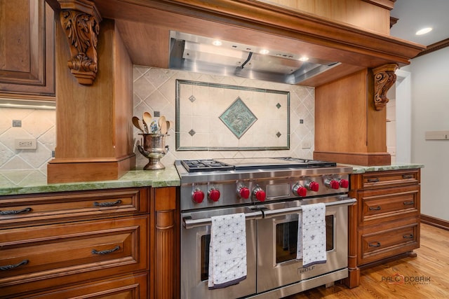 36955 N Fox Hill Dr, Wadsworth, IL 60083 - kitchen with range with two ovens, tasteful backsplash, light wood-style floors, exhaust hood, and brown cabinets