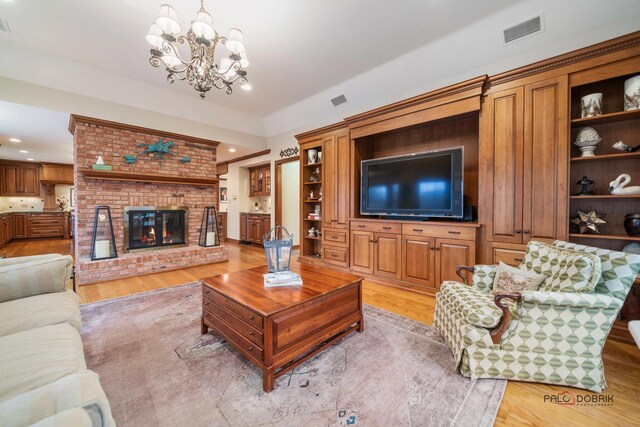 36955 N Fox Hill Dr, Wadsworth, IL 60083 - living room with light wood finished floors, recessed lighting, a brick fireplace, and a chandelier