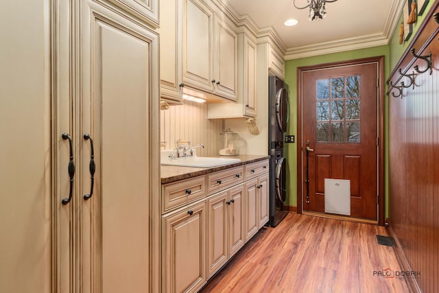 36955 N Fox Hill Dr, Wadsworth, IL 60083 - laundry area with stacked washer / dryer, cabinet space, light wood-style floors, and ornamental molding