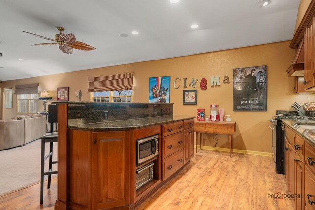 36955 N Fox Hill Dr, Wadsworth, IL 60083 - kitchen with stainless steel appliances, a ceiling fan, a breakfast bar, brown cabinets, and light wood finished floors