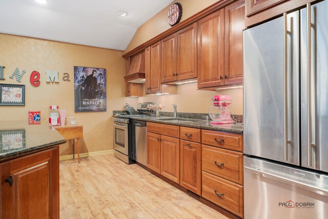 36955 N Fox Hill Dr, Wadsworth, IL 60083 - kitchen with stainless steel appliances, brown cabinetry, lofted ceiling, light wood-type flooring, and custom range hood