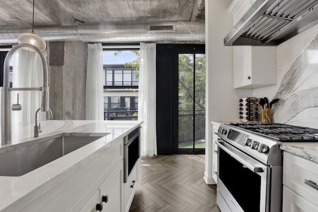 1033 W 14th Pl Unit 337, Chicago, IL 60608 - kitchen with stainless steel gas range oven, wall chimney range hood, a sink, and white cabinets