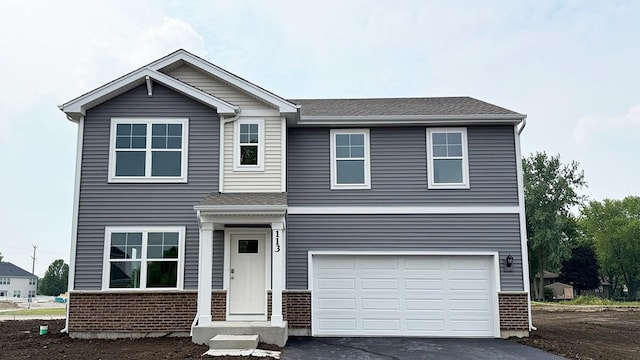 113 International Way, Joliet, IL 60436 - view of front of house with brick siding, asphalt driveway, and a garage