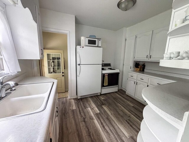 1711 17th Ave, Sterling, IL 61081 - kitchen with white appliances, white cabinetry, dark wood-style flooring, a sink, and light countertops