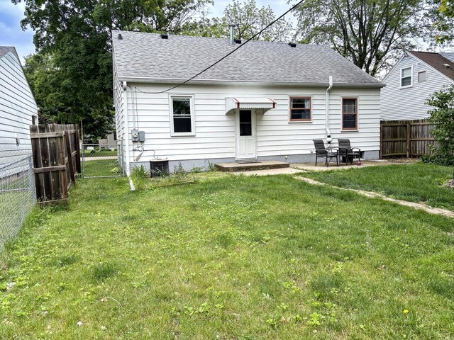 1711 17th Ave, Sterling, IL 61081 - back of house with a shingled roof, cooling unit, and a patio
