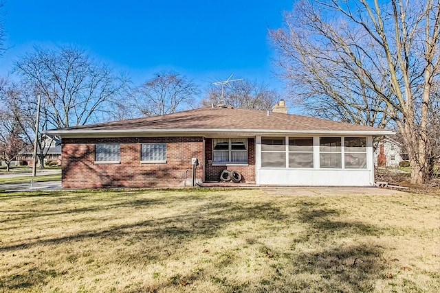 141 W 13th St, Chicago Heights, IL 60411 - view of front of house with a sunroom, a chimney, a front yard, and brick siding