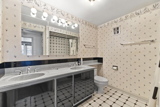 2213 Strawberry Ln, Glenview, IL 60026 - full bathroom featuring tile patterned floors, toilet, double vanity, wallpapered walls, and baseboards