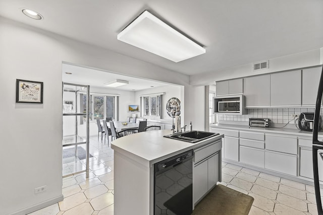 2213 Strawberry Ln, Glenview, IL 60026 - kitchen featuring black dishwasher, a sink, light countertops, stainless steel microwave, and a center island