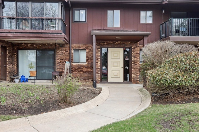 68 Pier Dr Unit 102, Westmont, IL 60559 - doorway to property with brick siding, board and batten siding, and a balcony