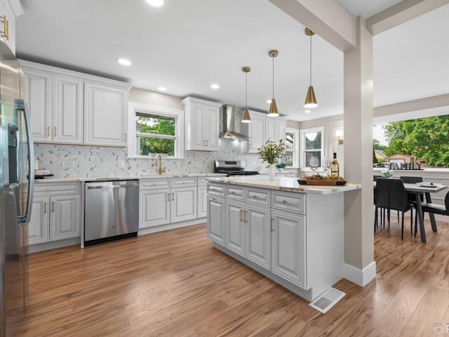 490 S Mchenry Ave, Crystal Lake, IL 60014 - kitchen featuring appliances with stainless steel finishes, wall chimney range hood, a sink, light countertops, and decorative backsplash