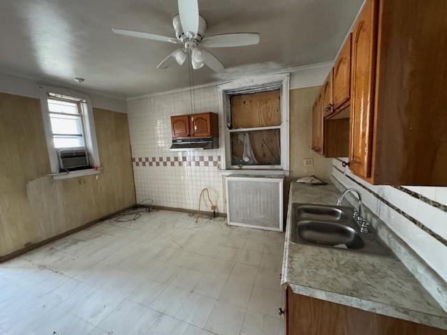 7952 S Elizabeth St, Chicago, IL 60620 - kitchen with a sink, a ceiling fan, brown cabinets, under cabinet range hood, and light countertops