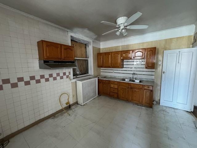 7952 S Elizabeth St, Chicago, IL 60620 - kitchen featuring brown cabinets, a sink, ceiling fan, light countertops, and crown molding