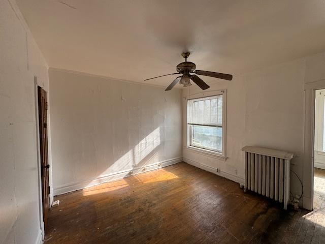 7952 S Elizabeth St, Chicago, IL 60620 - spare room featuring radiator, hardwood / wood-style flooring, ceiling fan, and baseboards