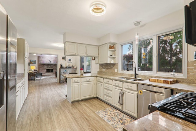 304 Fairhaven Dr, Winthrop Harbor, IL 60096 - kitchen with stainless steel appliances, a peninsula, light wood-style flooring, and tasteful backsplash