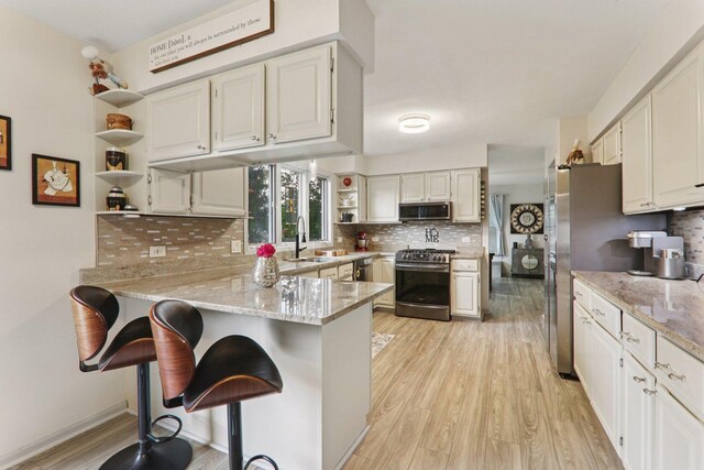 304 Fairhaven Dr, Winthrop Harbor, IL 60096 - kitchen featuring stainless steel appliances, open shelves, a peninsula, and light wood-style flooring