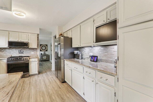 304 Fairhaven Dr, Winthrop Harbor, IL 60096 - kitchen with stainless steel appliances, backsplash, light wood-style floors, and light stone counters