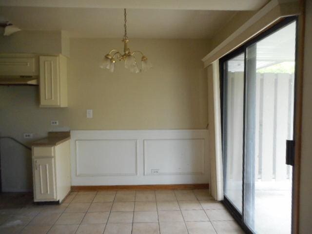 464 Buchanan Ct, Vernon Hills, IL 60061 - unfurnished dining area with healthy amount of natural light, a chandelier, wainscoting, and light tile patterned flooring