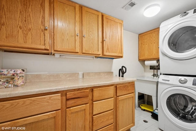 4747 Howard St Unit 205, Skokie, IL 60076 - washroom featuring stacked washer / drying machine, cabinet space, and light tile patterned floors