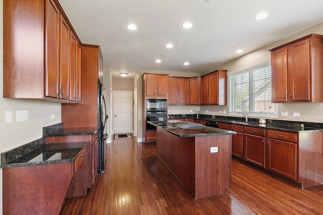 4 Tournament Dr S, Hawthorn Woods, IL 60047 - kitchen with black appliances, a sink, a center island, dark wood-style floors, and dark stone countertops