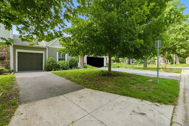 obstructed view of property featuring a garage, driveway, and a front yard