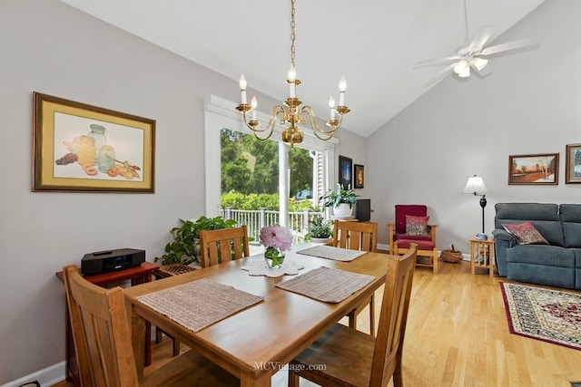 dining area featuring light wood finished floors, high vaulted ceiling, a chandelier, and a ceiling fan