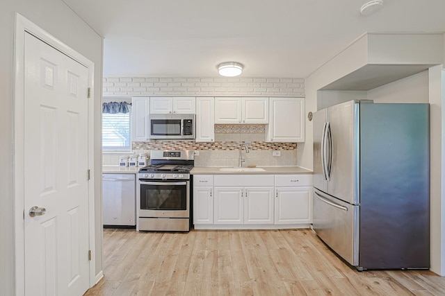 6124 Chase Ave, Downers Grove, IL 60516 - kitchen featuring stainless steel appliances, white cabinets, light countertops, tasteful backsplash, and light wood-style flooring